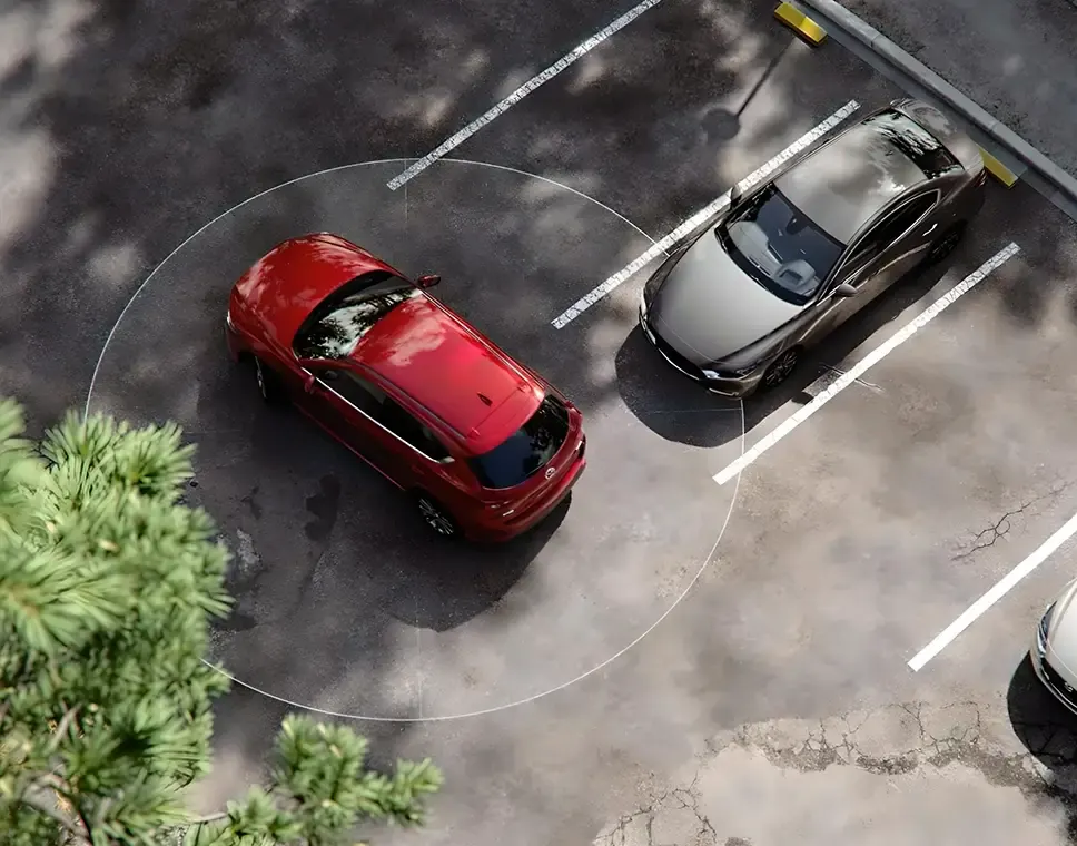 Vista aérea de un Mazda rojo en un estacionamiento con el círculo de detección de sus sensores